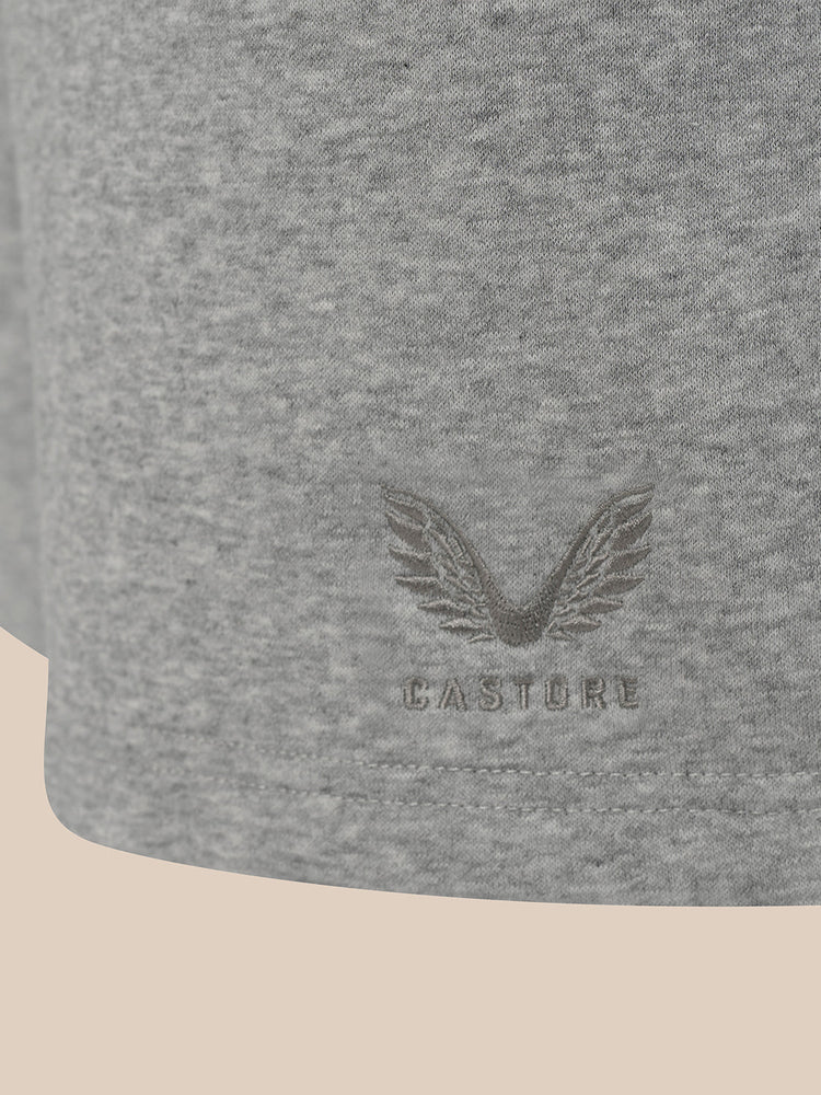Close-up of a heather gray fabric product, likely a sweatshirt or jacket sleeve, featuring an embossed winged logo and the brand name CASTORE.