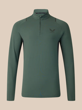 A dark green long-sleeve quarter-zip athletic top with a small wing logo on the left chest, displayed on a neutral beige background.