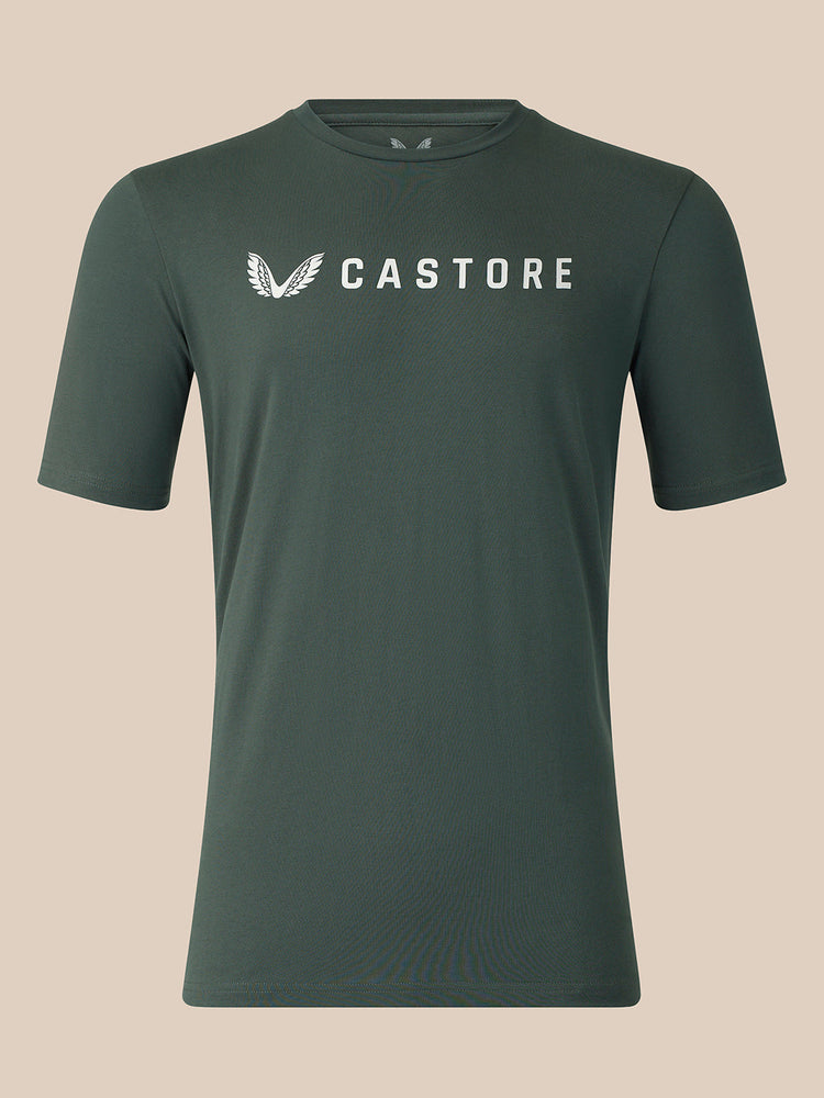 A dark green crewneck t-shirt with a white Castore logo printed on the chest, displayed against a solid beige background.