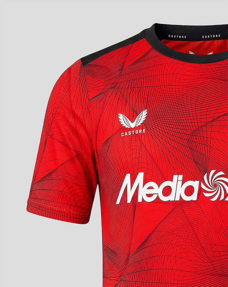 Front view of the red Feyenoord junior jersey with bold geometric pattern and Castore branding at the neckline