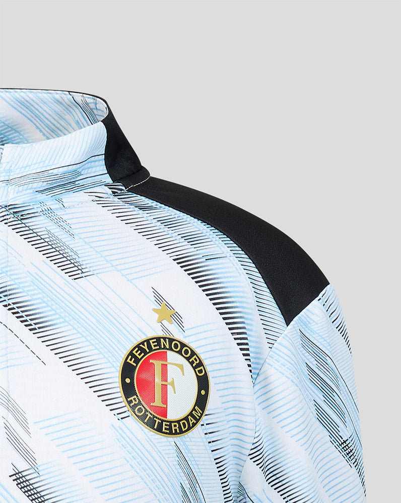 Close up of the Feyenoord crest on the chest of the junior away midlayer top with pale blue pattern.