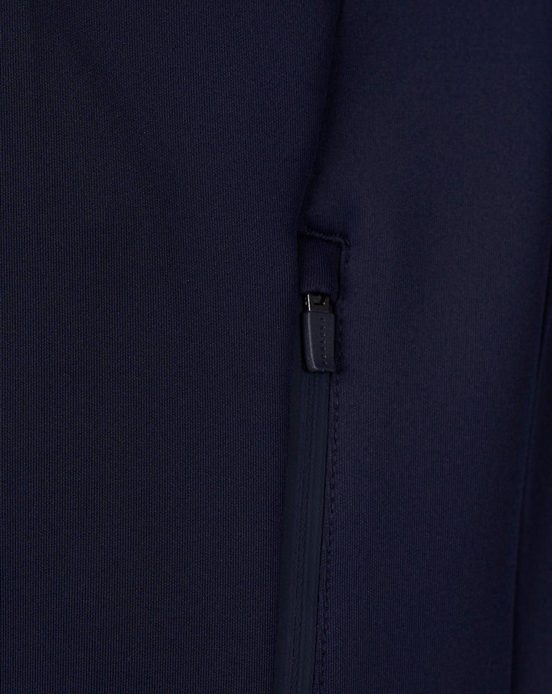 Close-up of navy Travel hoodie showing a zippered side pocket detail.