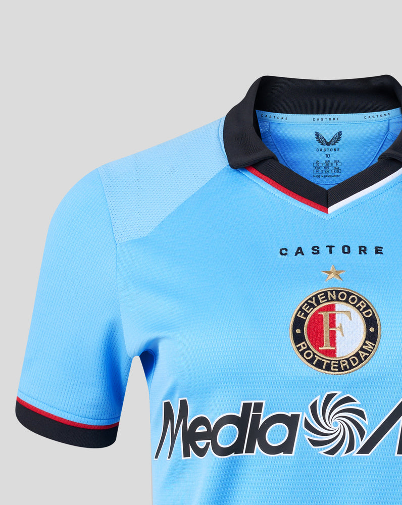 Close-up of the blue away shirt collar with black trim and Castore branding along the neck.
